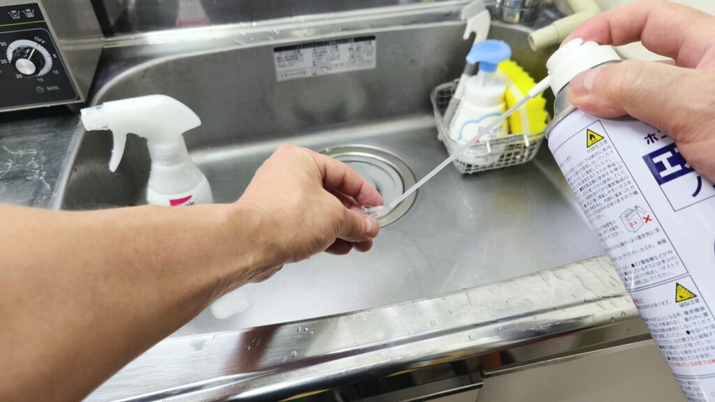 エアブロアーでイヤモールドのチューブ内の水分を抜く様子