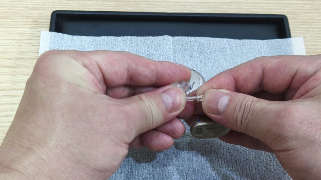 洗浄後のイヤモールドを補聴器本体に再接続する様子