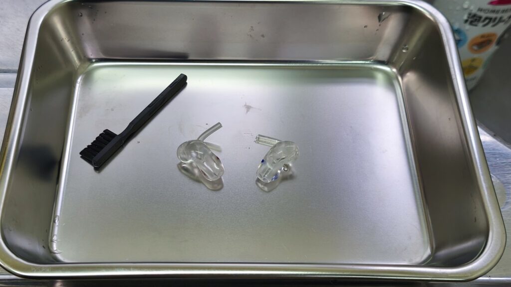 洗浄を終えたイヤモールド2個と補聴器用ブラシ